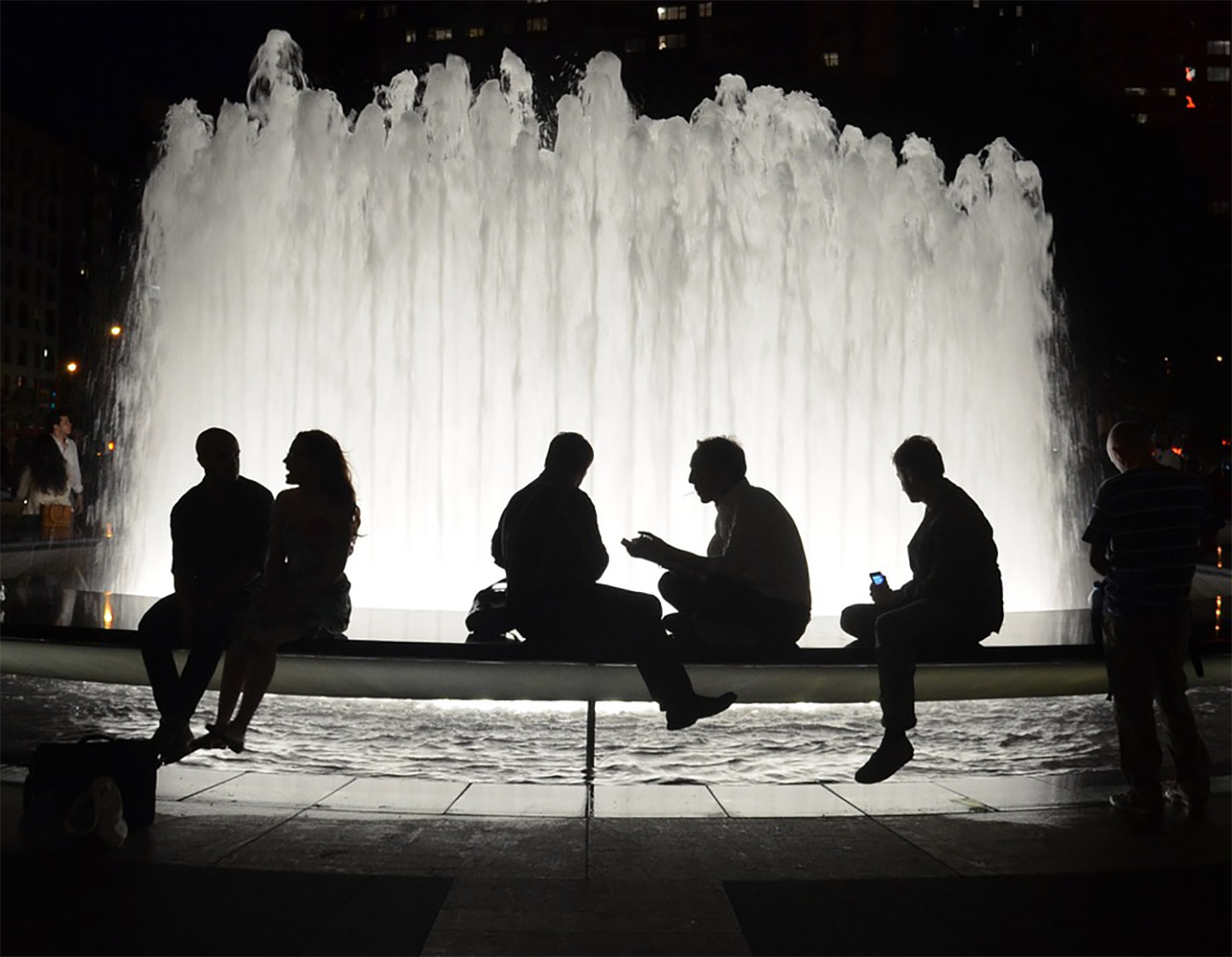 People talking in front of a fountain