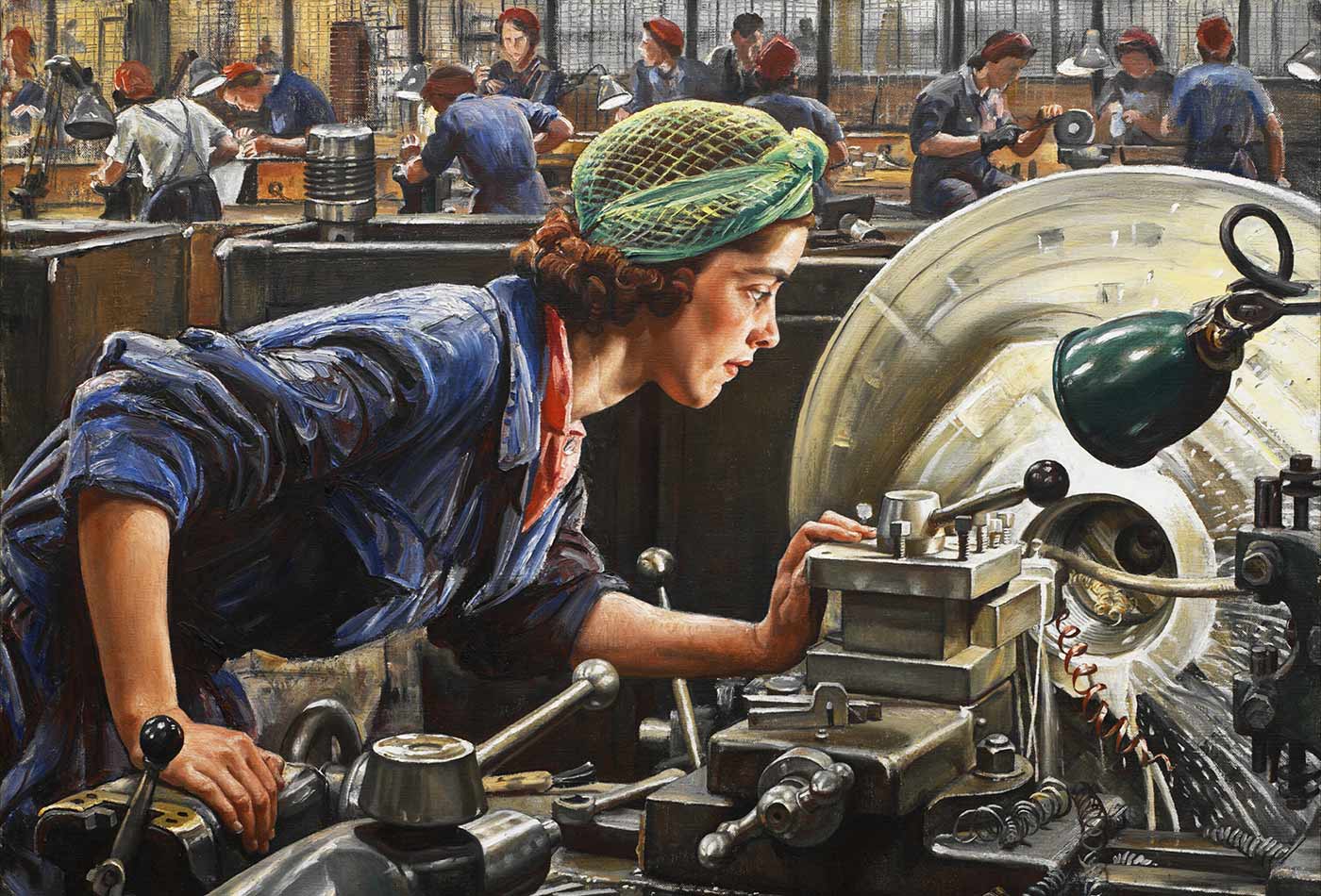 A young factory worker at work on an industrial lathe.