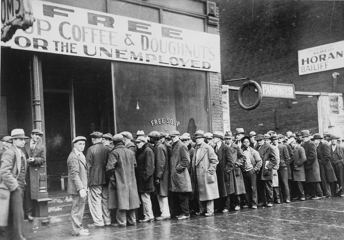 Unemployed men queued outside a depression soup kitchen opened in Chicago by Al Capone.